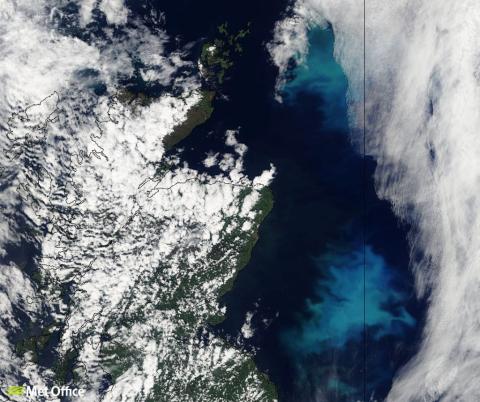 Satellite image showing the northeastern coast of Scotland, partially covered by white clouds. The sea to the right displays light blue and turquoise hues, indicating possible phytoplankton blooms or varying water depths